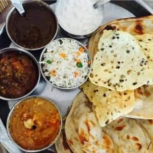 Amritsar food thali with naan, chickpeas, dal makhani and lassi, traditional Punjabi food in Amritsar