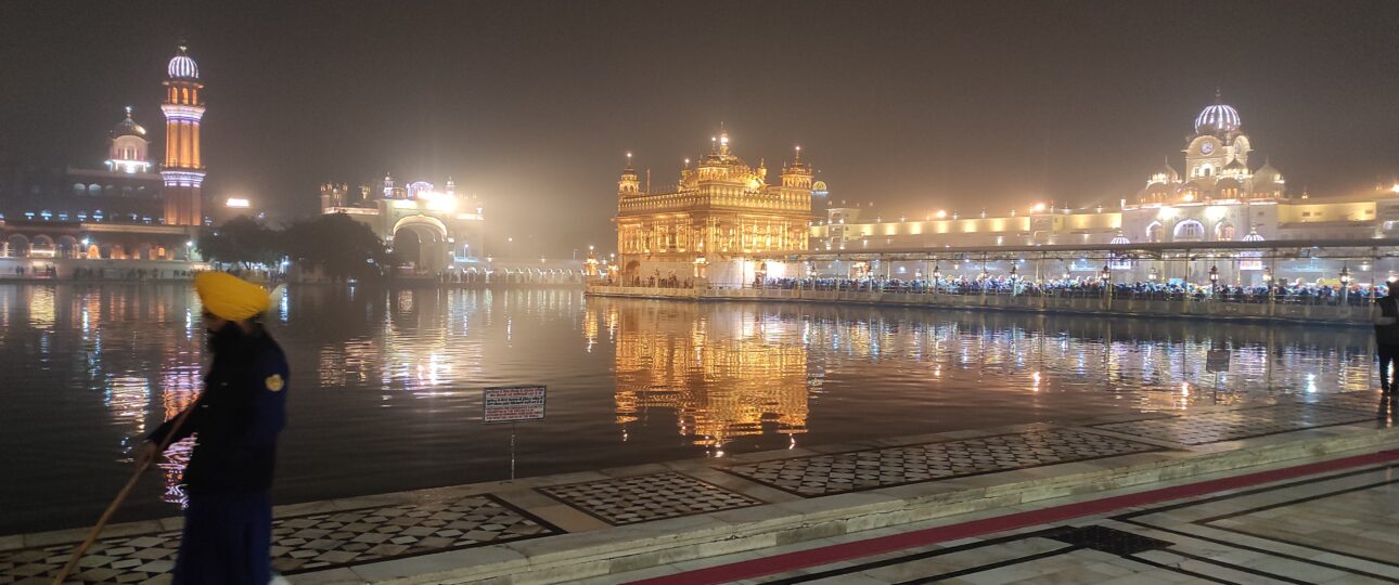 Guard standing near the sacred Sarovar at the Golden Temple, Amritsar, reflecting Sikh heritage and spiritual tranquility