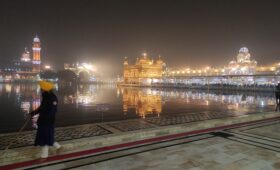 Guard standing near the sacred Sarovar at the Golden Temple, Amritsar, reflecting Sikh heritage and spiritual tranquility