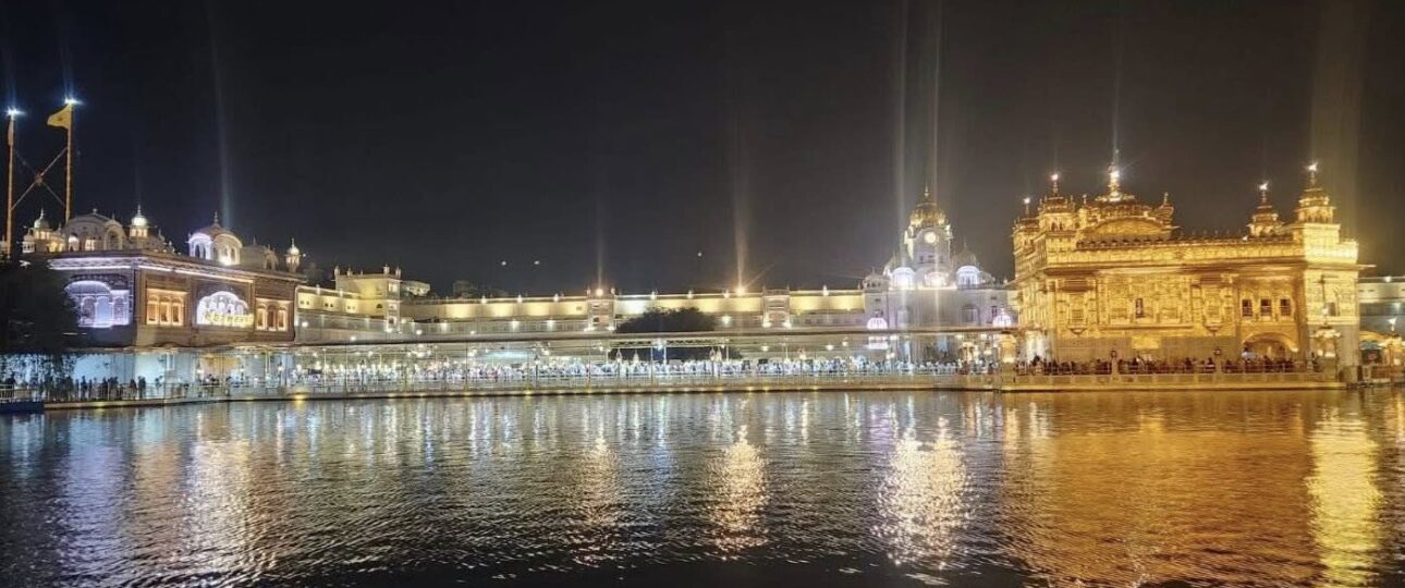 Golden Temple Amritsar illuminated at night with golden reflections on the sacred pool during a British Architecture Tour of Amritsar by E-Rickshaw or Tuk Tuk